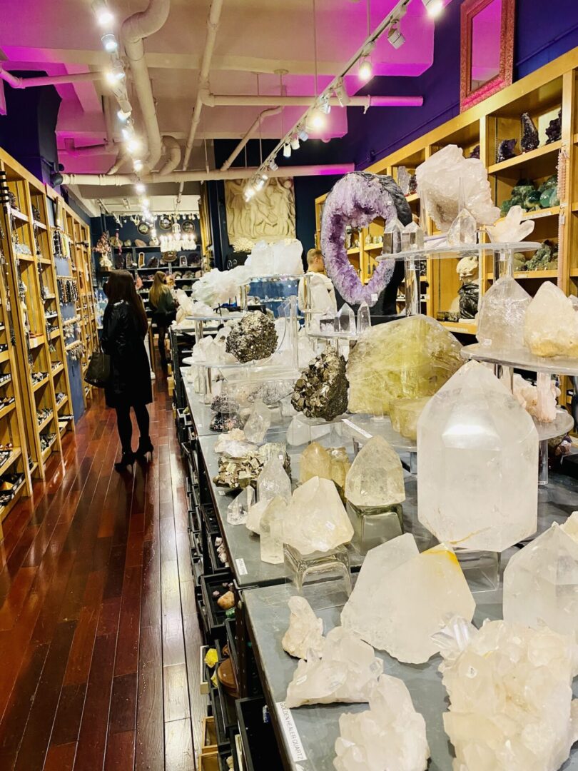 A woman walks down the aisle of an indoor store.